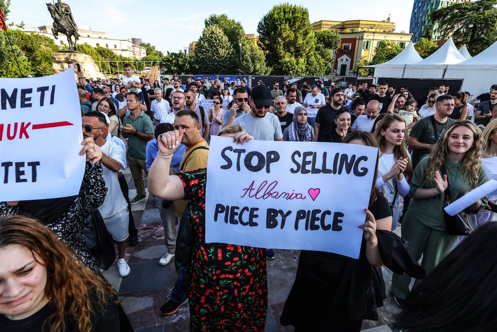 TIRANA, ALBANIA - JUNE 2: Protesters gather under the slogan "Albania is not for sale", asking for the resignation of Albanian Prime Minister Edi Rama, in front of Albanian Government building on June 2, 2026 in Tirana, Albania. Recently protests have escalated into violent clashes over illegal bulldozing in the protected PishÎ Poro-Narta landscape, sparking solidarity rallies in Tirana. This environmental destruction is driven by the government's push for luxury tourism developments and has drawn severe backlash from the European Union. The European Commission is actively monitoring the crisis, explicitly warning Tirana that failing to halt this habitat destruction and ignoring environmental regulations will directly jeopardise Albania's EU accession process under Chapter 27 (Environment). (Photo by Armando Babani/Getty Images)