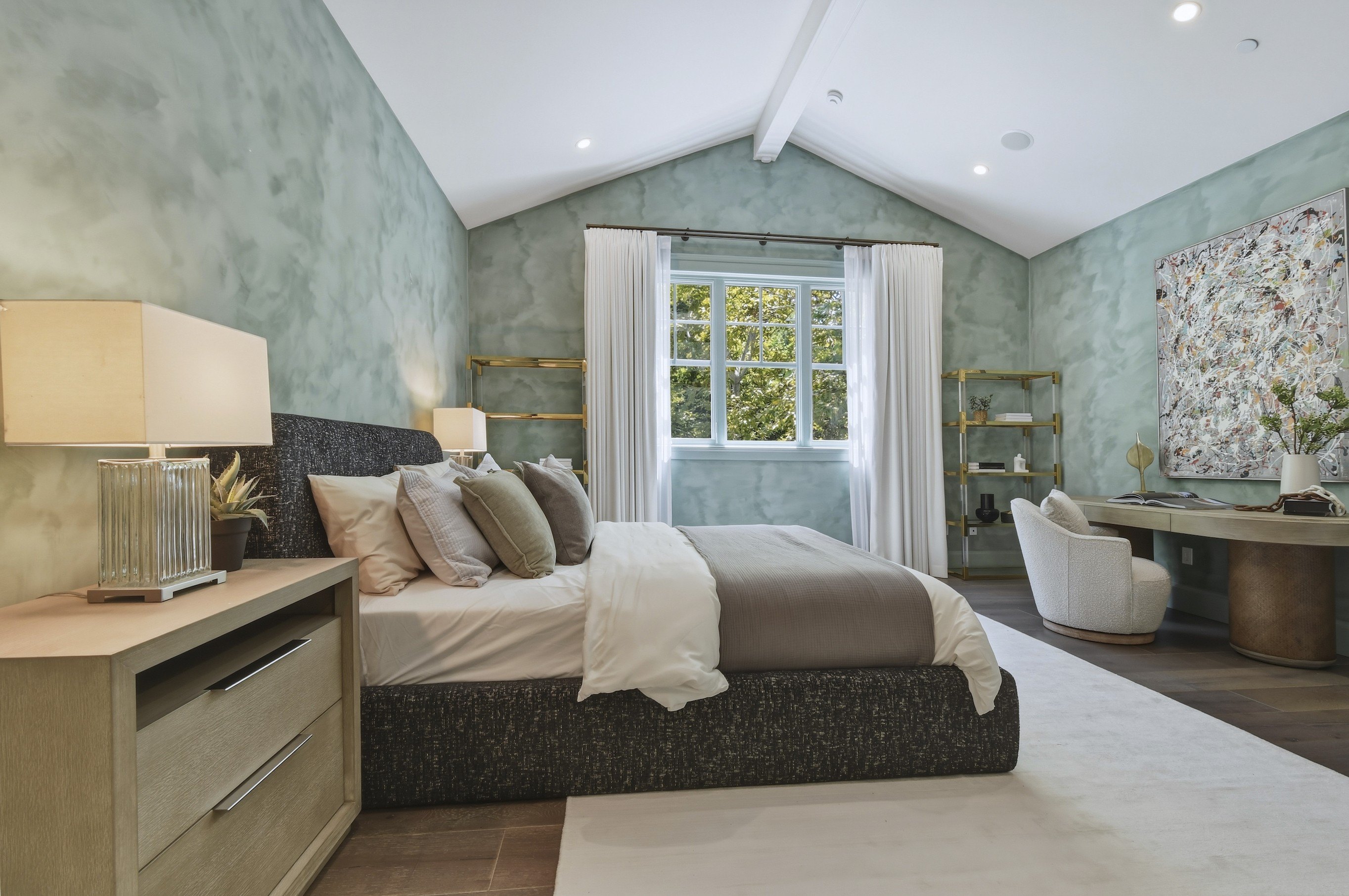 Spacious Bedroom Suite with Sage Green Accent Wall, Vaulted Ceiling, and Desk Nook