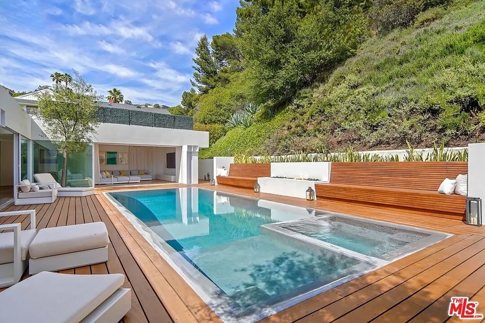 Luxury backyard patio with a rectangular swimming pool, integrated hot tub, and wood deck.