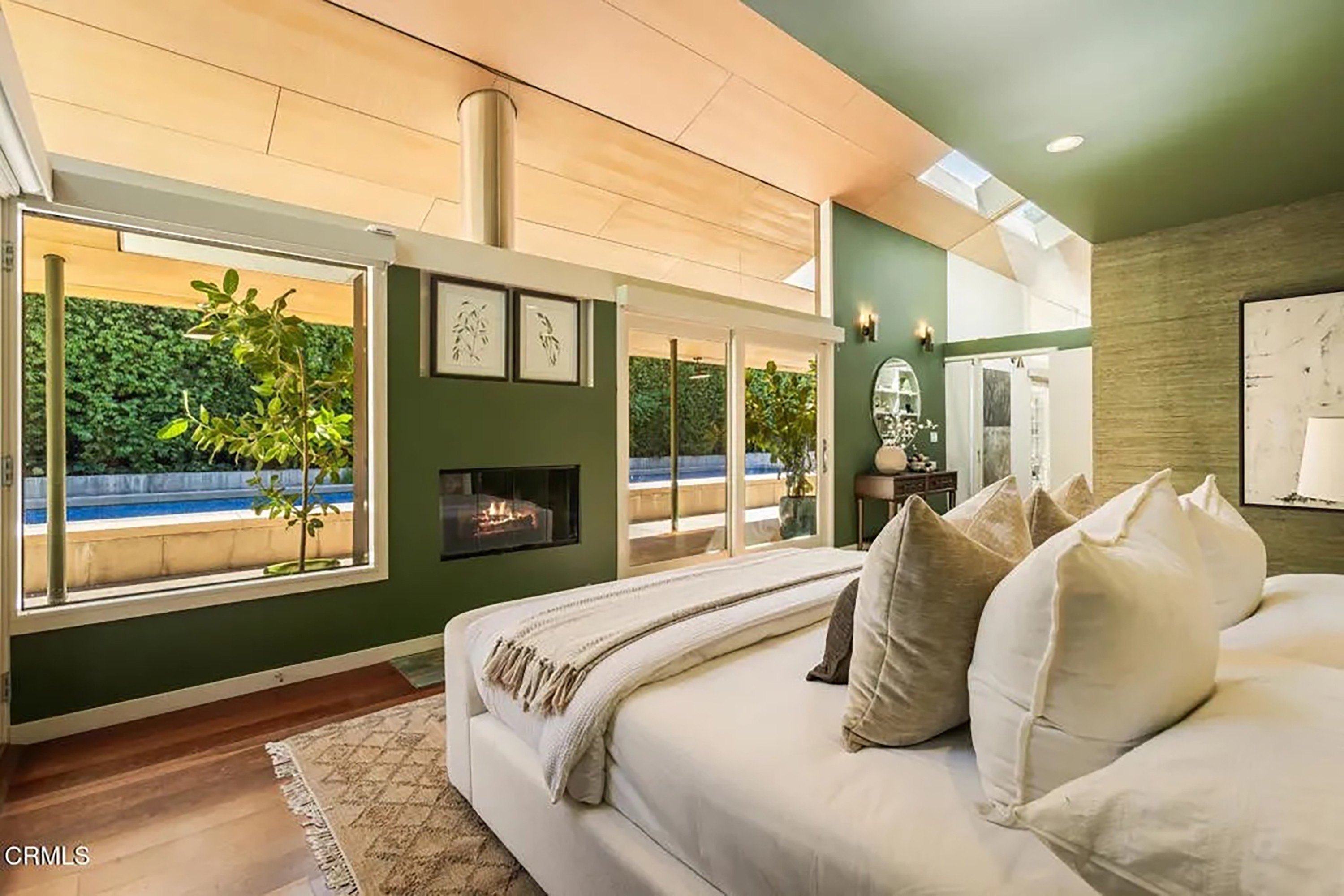 Primary Bedroom Suite with Green Accent Walls and Built-In Fireplace