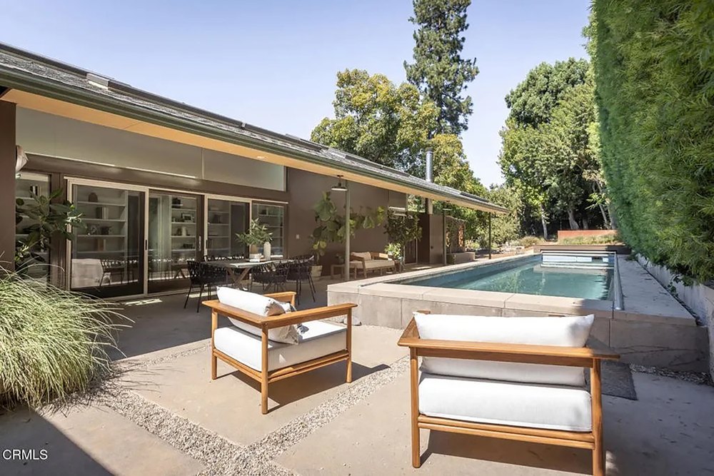 Outdoor Pool Terrace with Lounge Chairs and Tall Privacy Hedges